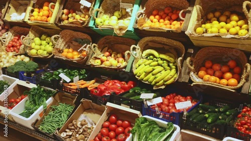 Colorful market counter with large assortment of fresh fruits and vegetables for sale