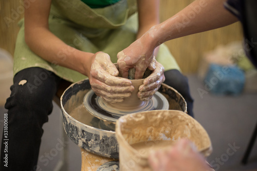 Potter creates a clay jug with his hands photo