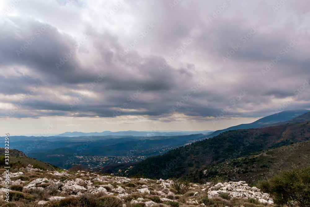 A beautiful view of the Alps mountains hills with the French Provence / Cote d'Azur towns and multilayered mountain ranges in the background captured during a hike