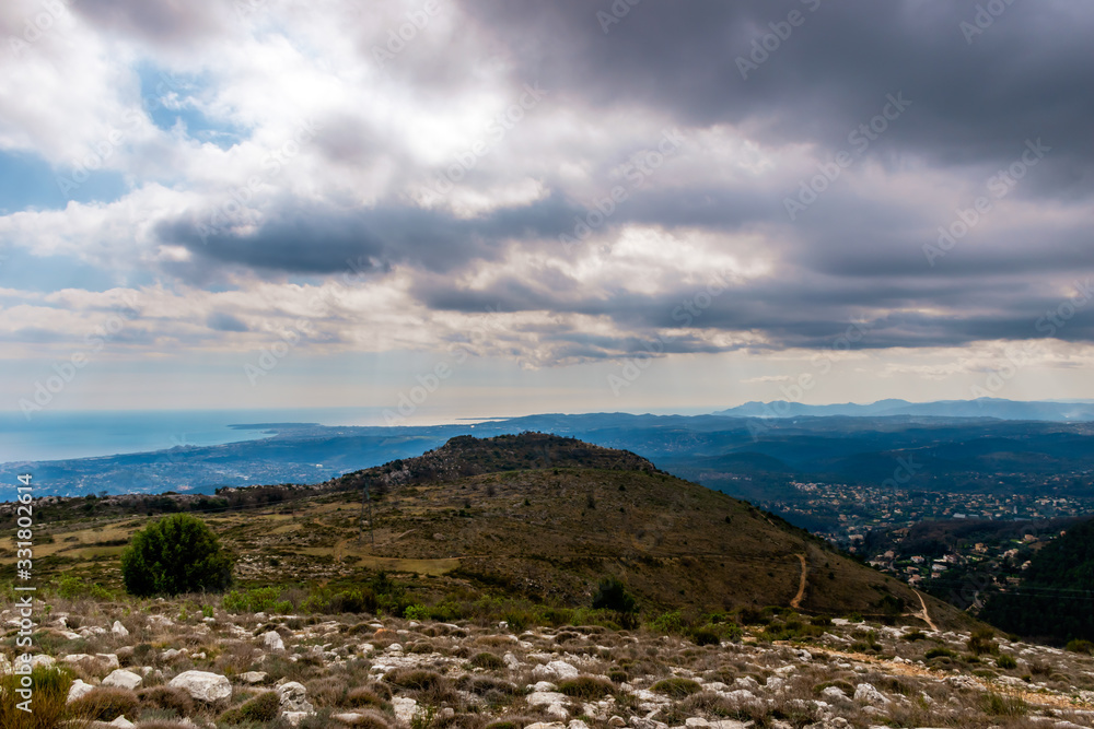 A beautiful view of the Alps mountains range with the French Provence / Cote d'Azur towns and the Mediterranean Sea coastline in the background captured during a hike