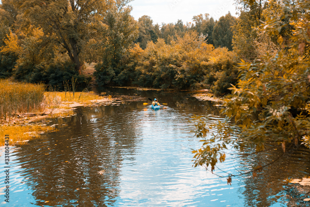 A guy and a girl canoe paddling the river in fall A guy and a girl canoe paddling the river in fall