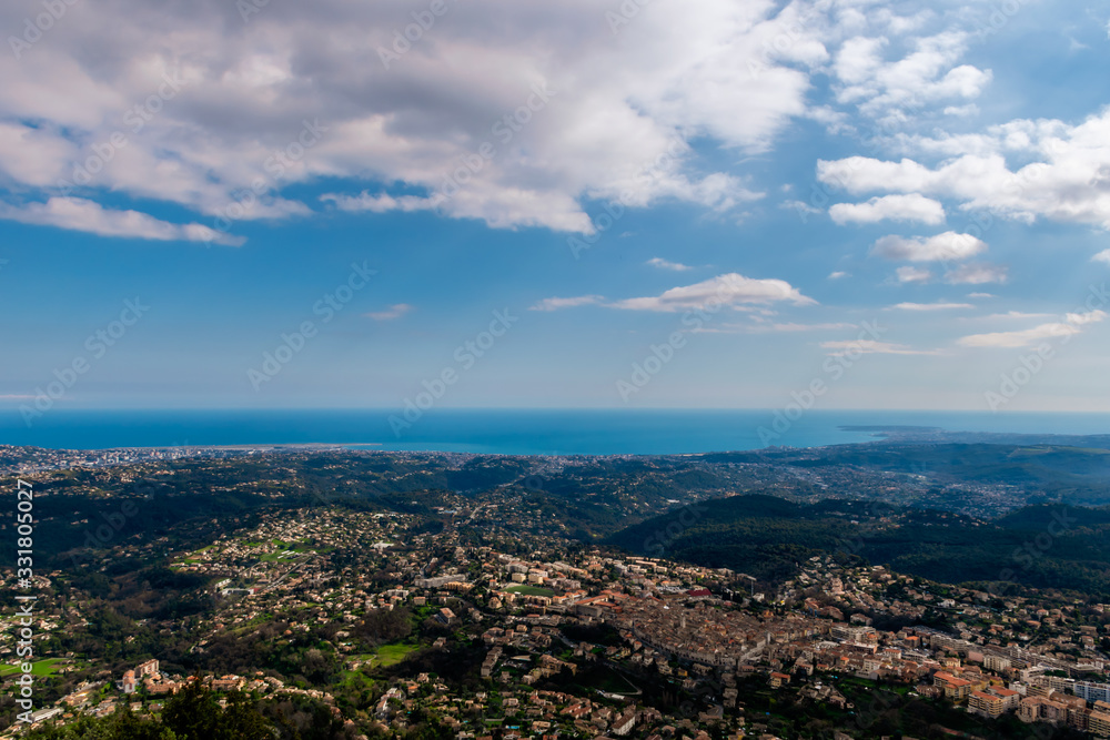 A wide / high angle panoramic view of Vence buildings and other towns covering the low Alps mountains hills with the Mediterranean Sea coastline on the horizon (French Côte d'Azur/ Provence/ Riviera)