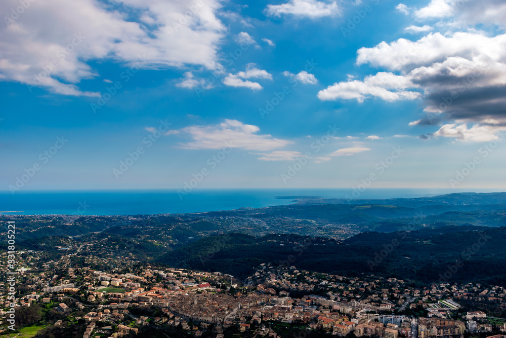 A wide / high angle panoramic view of Vence buildings and other towns covering the low Alps mountains hills with the Mediterranean Sea coastline on the horizon (French Côte d'Azur/ Provence/ Riviera)