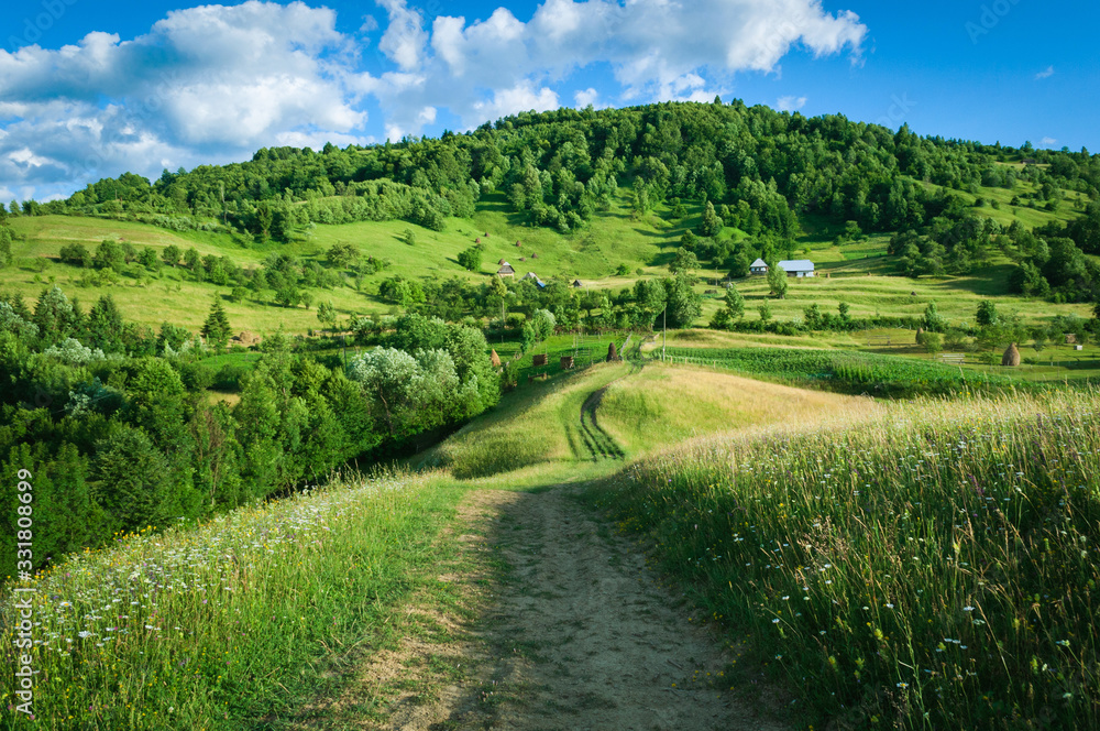 A peaceful landscape, green hills in spring time. A country road is cutting through the immaculate grass, illustrating the idea of travel , tourism or exploring A peaceful landscape, green hills in spring time. A country road is cutting through the immaculate grass, illustrating the idea of travel , tourism or exploring