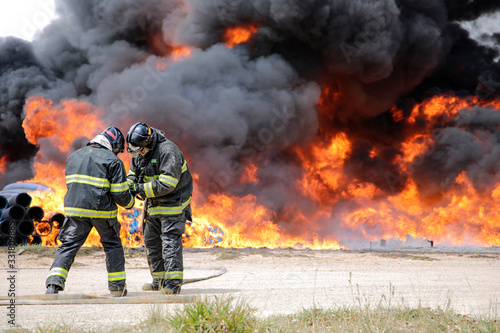 Two firefighters preparing to contain the flames