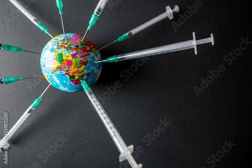 A globe full of syringes. To illustrate the need for vaccine to fight the global pandemic caused by the covid-19 virus. photo