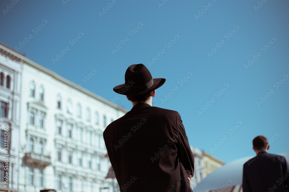 Orthodox Jew from the back with a hat in the afternoon Orthodox Jew from the back with a hat in the afternoon