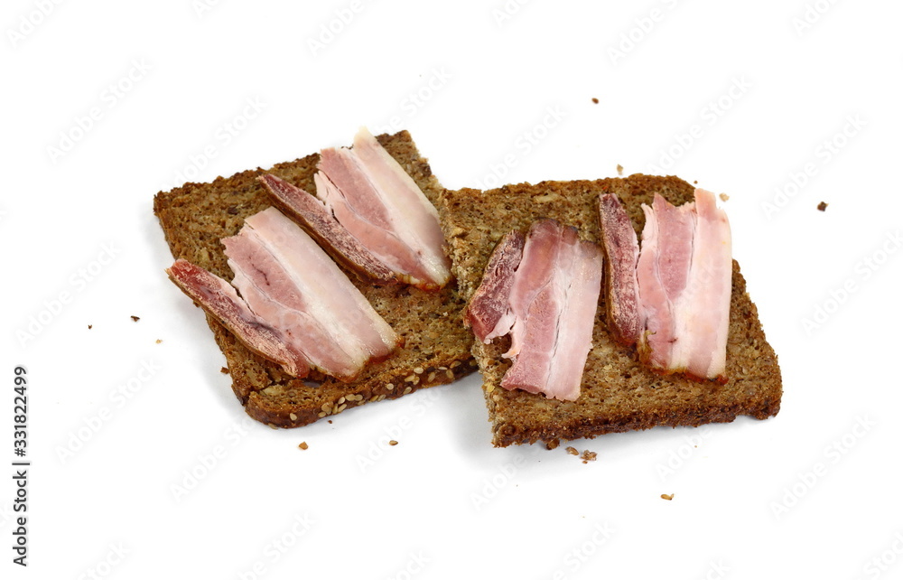 Slices of wholemeal dark bread with smoked bacon isolated on a white background, close-up 