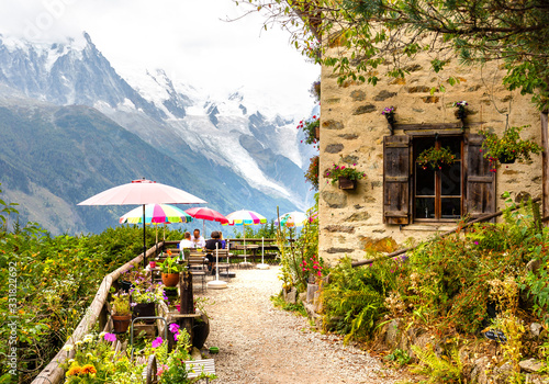 Tourists sitting restaurant terrace Mont Blanc mountain view