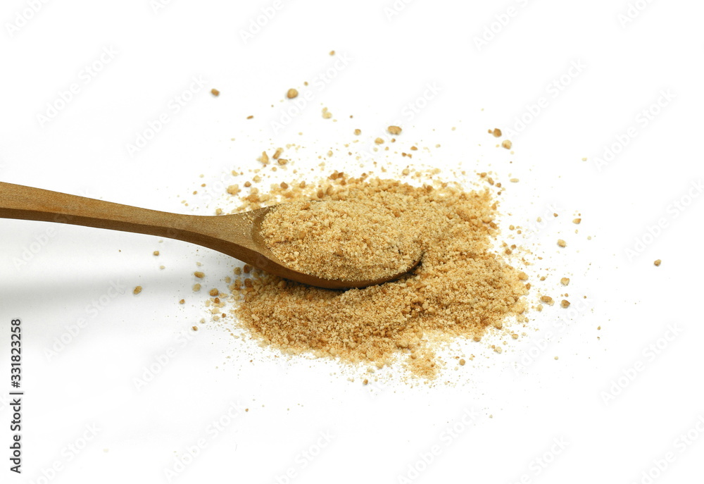 Ground biscuits in a wooden spoon on white background. Ground biscuits in a wooden spoon on white background.