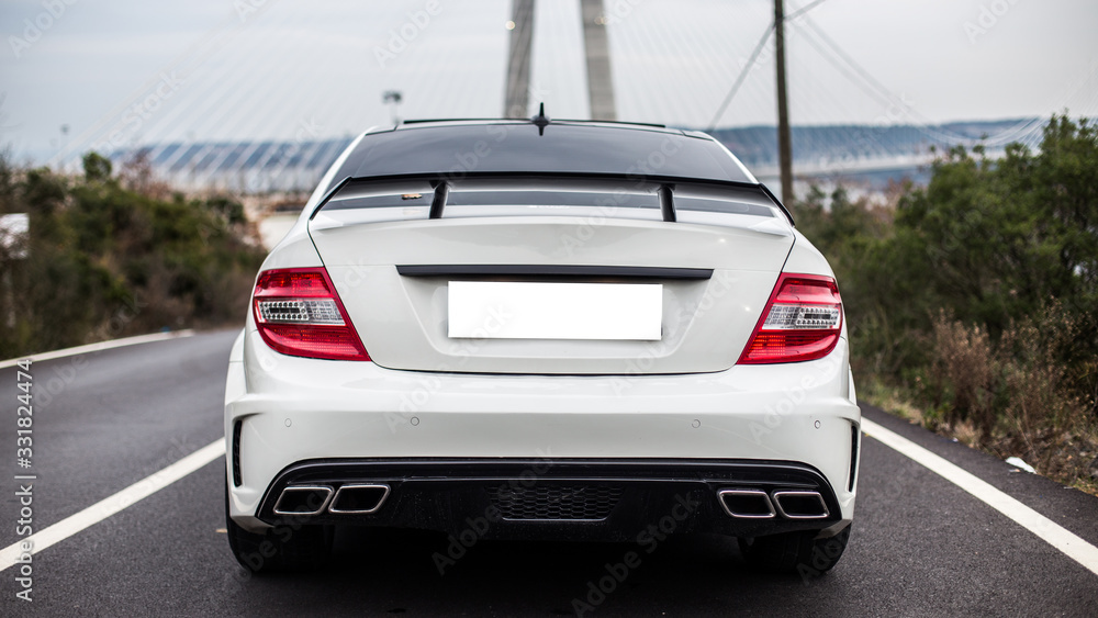 White business class sedan parked on the road. Place with a view White business class sedan parked on the road. Place with a view