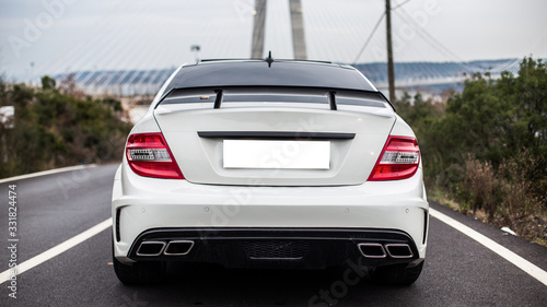 Canvas Print White business class sedan parked on the road. Place with a view