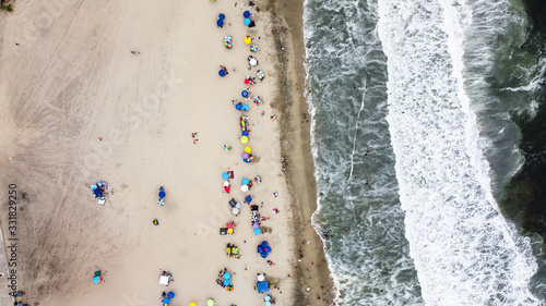 Beautiful aerial view with drone to one of the beaches south of Lima in Peru where you can see umbrellas and people enjoying the summer