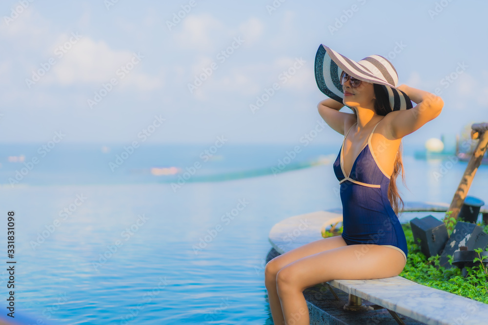 Obraz premium Portrait beautiful young asian woman relax around swimming pool in hotel resort
