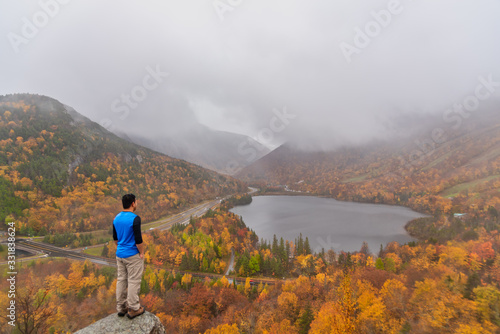 Man posing infront of beautiful Echo Lake from Artists Bluff Loop in New Hampshire USA