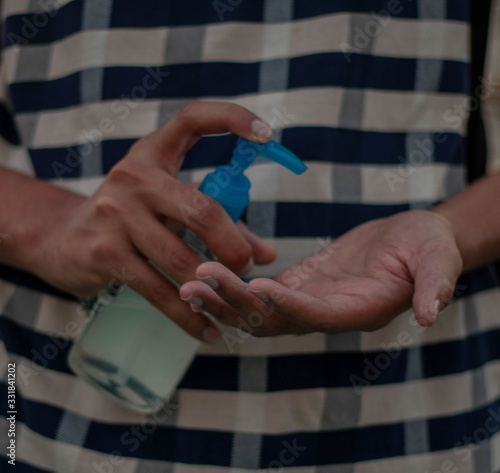 Close up view of using small portable antibacterial hand sanitizer on hands.selective focus