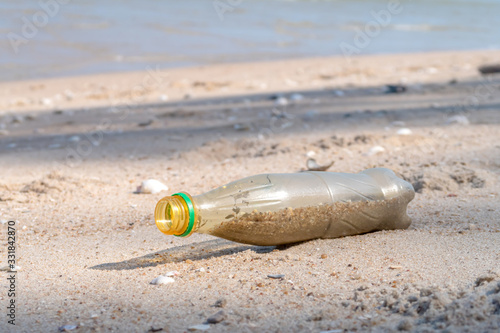 Plastic bottle is on the beach leave by tourist