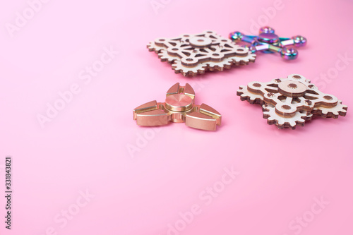 fidget finger spinners antistress, anxiety relief toy on pink background. spinners made different materials. Metal wooden.