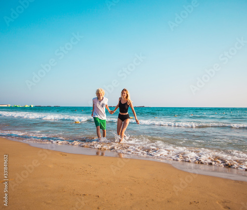 Happy young couple having fun at beach on sunny day