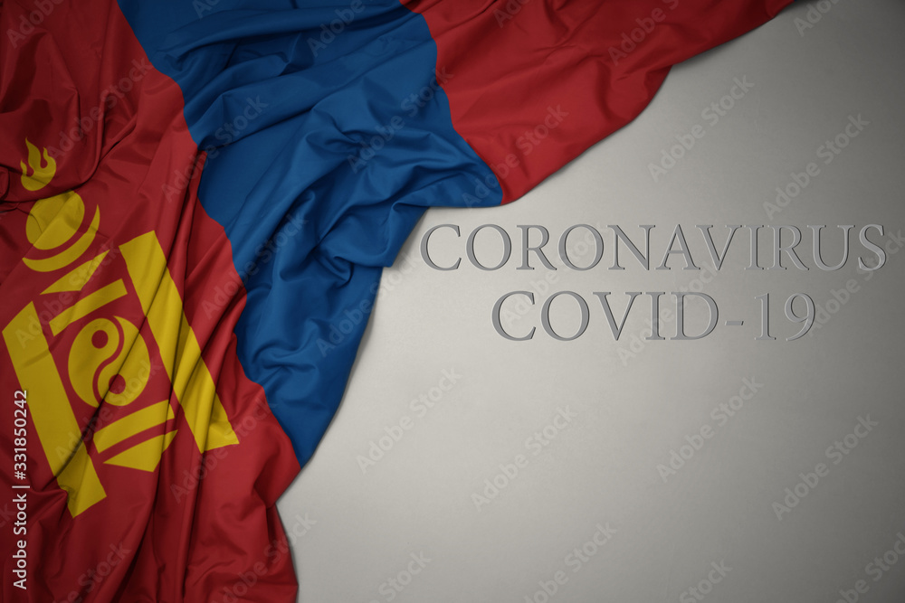 waving national flag of mongolia on a gray background with text coronavirus covid-19 . concept.
