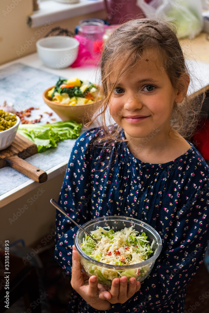 Plakat Little young vegan, vegetarian girl kid with food in hands. Healthy eating. Family health care concept. Fresh detox cabbage salad