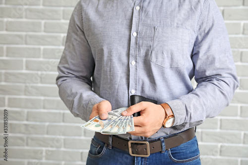Man with purse and money on brick background, closeup