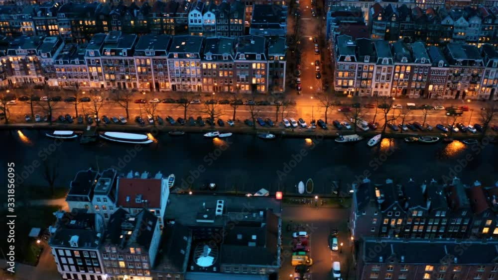 Amsterdam, Netherlands, Aerial top view of water canal and old town in evening, historic downtown, drone footage. Amsterdam, Netherlands, Aerial top view of water canal and old town in evening, historic downtown, drone footage.