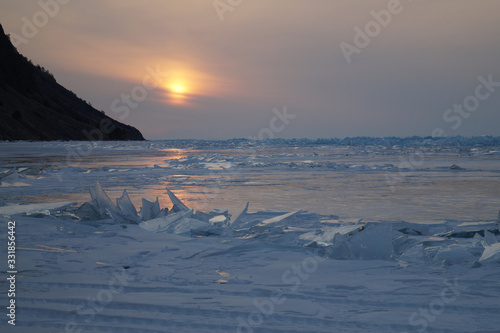 the sun sets behind the ice hummocks
