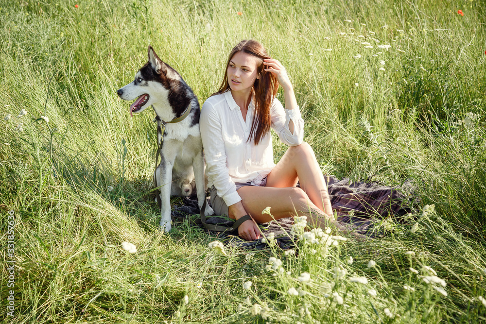 Beautiful woman playing with husky dog outdoors at park. Beautiful woman playing with husky dog outdoors at park.