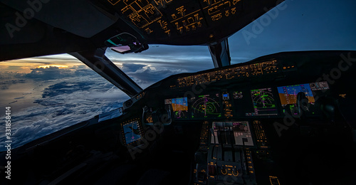 Boeing 787 flightdeck view of the sunrise high over the Pacific ocean.