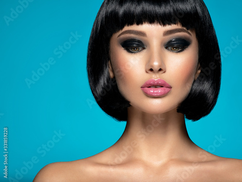 Glamour fashion model with black gloss make-up. Beautiful fashion woman with a bob hairstyle. Attractive white girl with black eye-makeup. Stylish fashionable concept. Art.