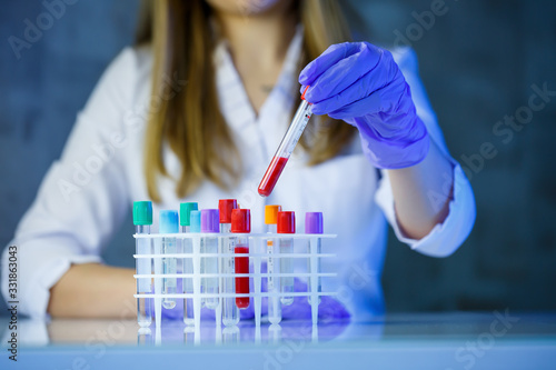 A medical professional, laboratory assistant, doctor performs an analysis in a laboratory, uses test tubes, a pipette and a petri dish for the presence of bacteria in the human body