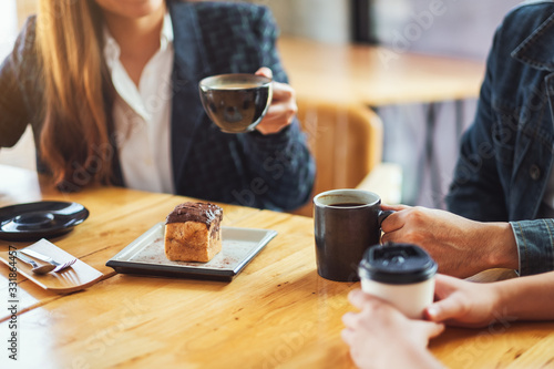 Closeup image of people enjoyed talking  eating and drinking coffee together in cafe
