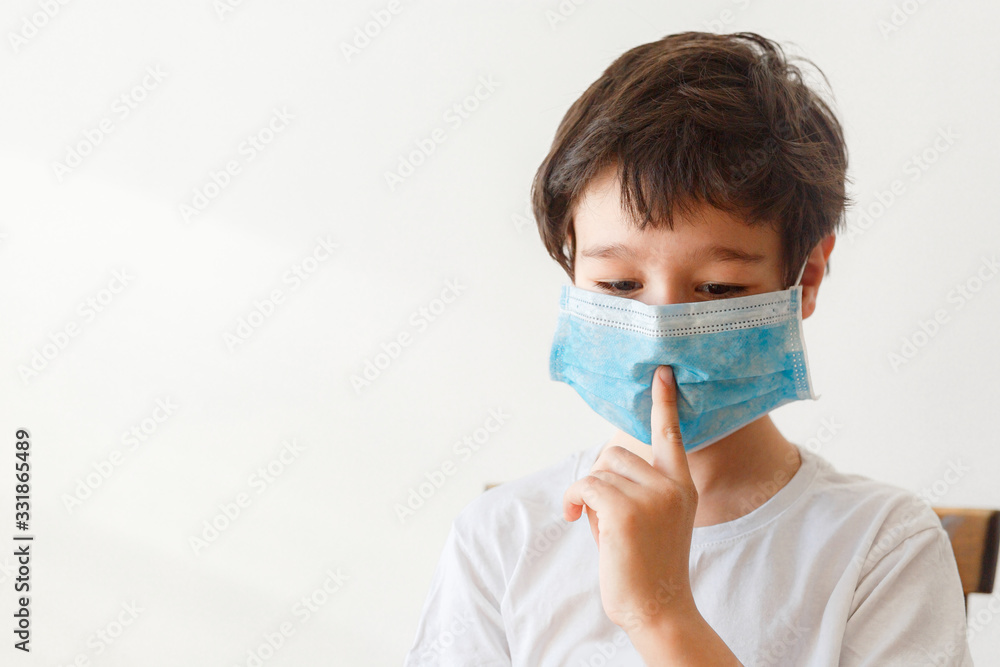 Cute little asian  boy wearing health mask, looking up, isolated over white background
