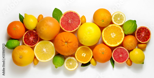 Fototapeta Naklejka Na Ścianę i Meble -  Close up image of juicy organic whole and halved assorted citrus fruits, green leaves & visible core texture, isolated white background, copy space. Vitamin C loaded food concept. Top view, flat lay.