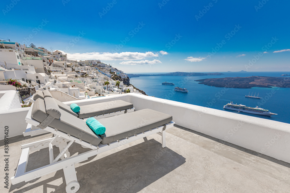 Loungers chairs in Santorini landscape and sea view. Beautiful summer vacation and holiday destination, white architecture, luxury hotel resort. Santorini, Greece