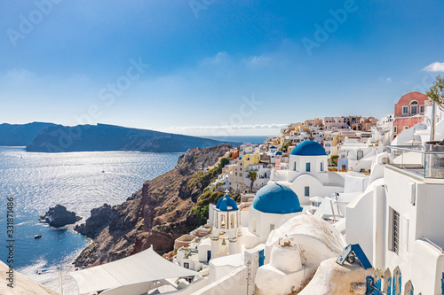 Amazing summer landscape, luxury vacation. Oia town on Santorini island, Greece. Traditional and famous houses and churches with blue domes over the Caldera, Aegean sea