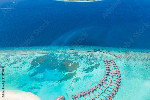 Perfect aerial landscape, luxury tropical resort or hotel with water villas and beautiful beach scenery. Amazing bird eyes view in Maldives, landscape seascape aerial view over a Maldives