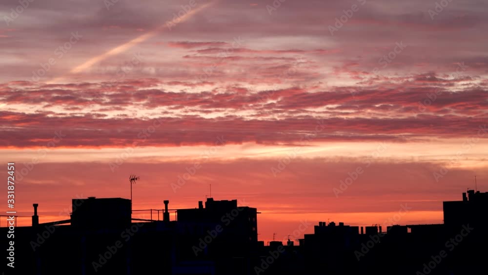 Sunset with the orange and pink sky the city roofs. Camera movement from bottom to top. Barcelona, Spain Sunset with the orange and pink sky the city roofs. Camera movement from bottom to top. Barcelona, Spain