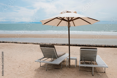 two chairs and umbrella on the beach  vacation time after covid-19