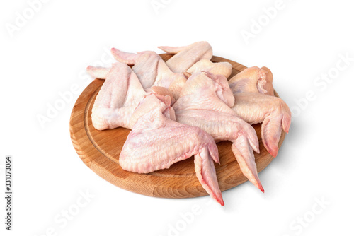 Raw chicken wings on wooden board isolated on white background.