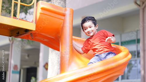 Cute little Asian 2 year old toddler baby boy child playing on a slide at indoor playground in department store, Baby Sliding Down Slide, Kid first experience concept.