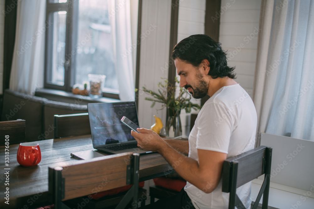 Workplace at home. A man works at a laptop at home Workplace at home. A man works at a laptop at home