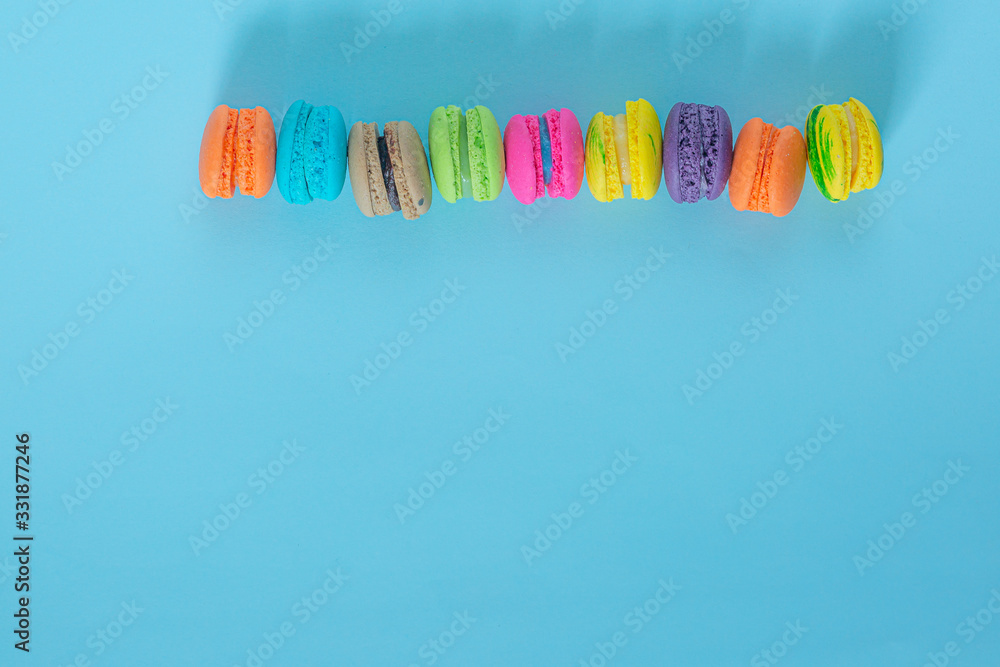 Cake macaron or macaroon on turquoise background from above, colorful almond cookies, pastel colors, vintage card, top view Cake macaron or macaroon on turquoise background from above, colorful almond cookies, pastel colors, vintage card, top view