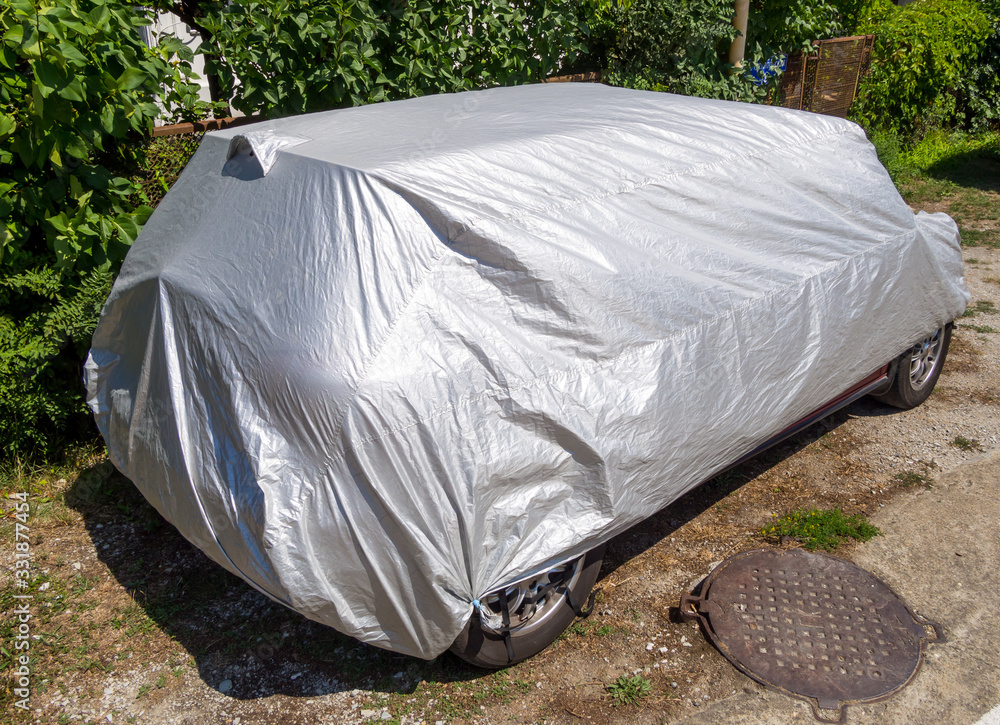 The car is covered with a protective cover