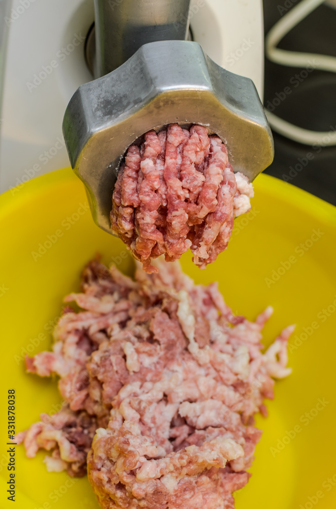 Meat is minced in an electric meat grinder Meat is minced in an electric meat grinder