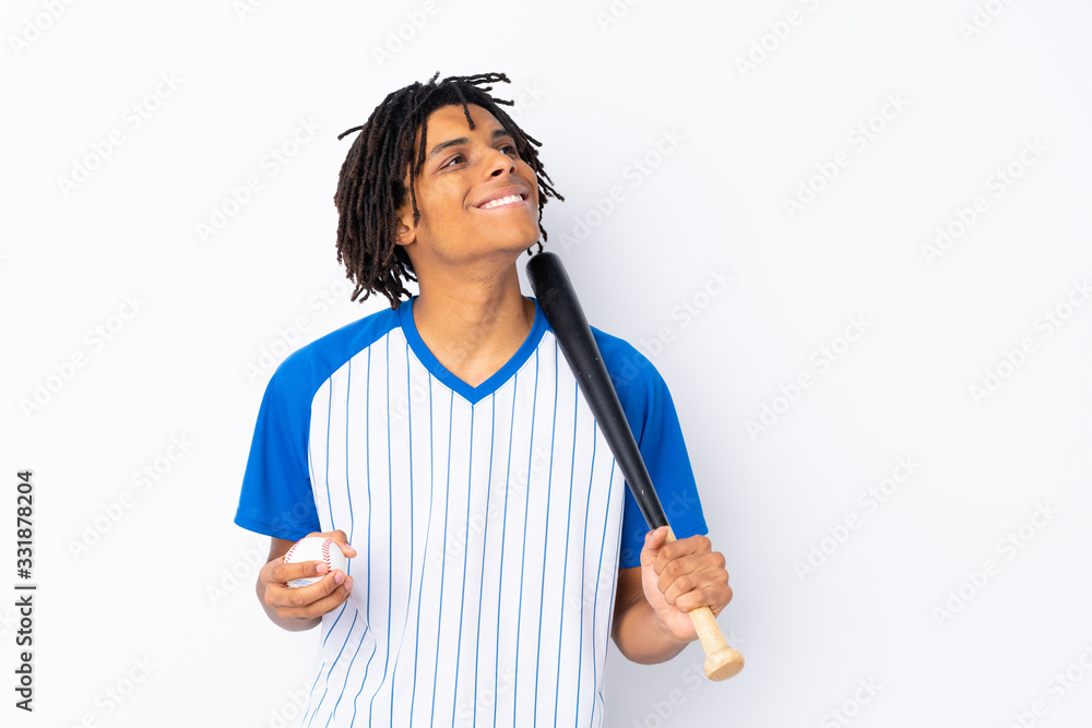 Young African American man playing baseball over isolated white background looking up while smiling Young African American man playing baseball over isolated white background looking up while smiling