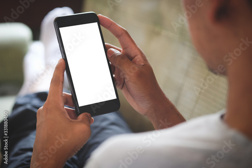 Cropped shot view of man hands holding smart phone with blank copy space screen for your text message or information content, female reading text message on cell telephone during in urban setting.
