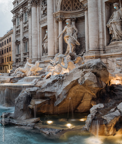 Statues at the trevi fountain wearing a surgical face masks as a symbol of the Rome lockdown caused by coronavirus outbreak