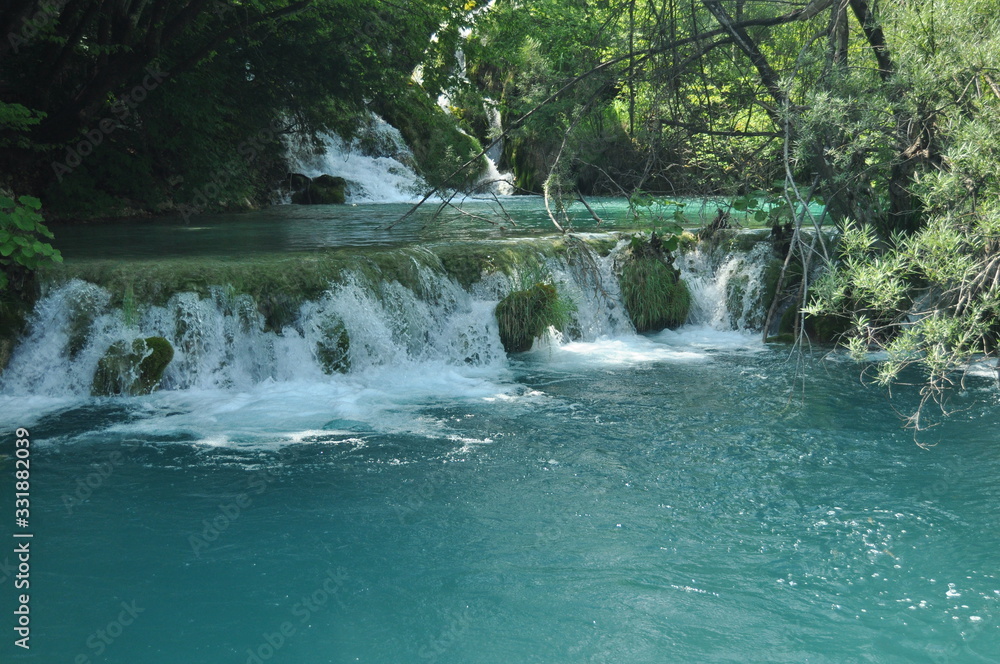 Obraz premium High waterfall, the water flowing from the rocks into the lake. National Park Plitvice Lakes. Tourism in Croatia.